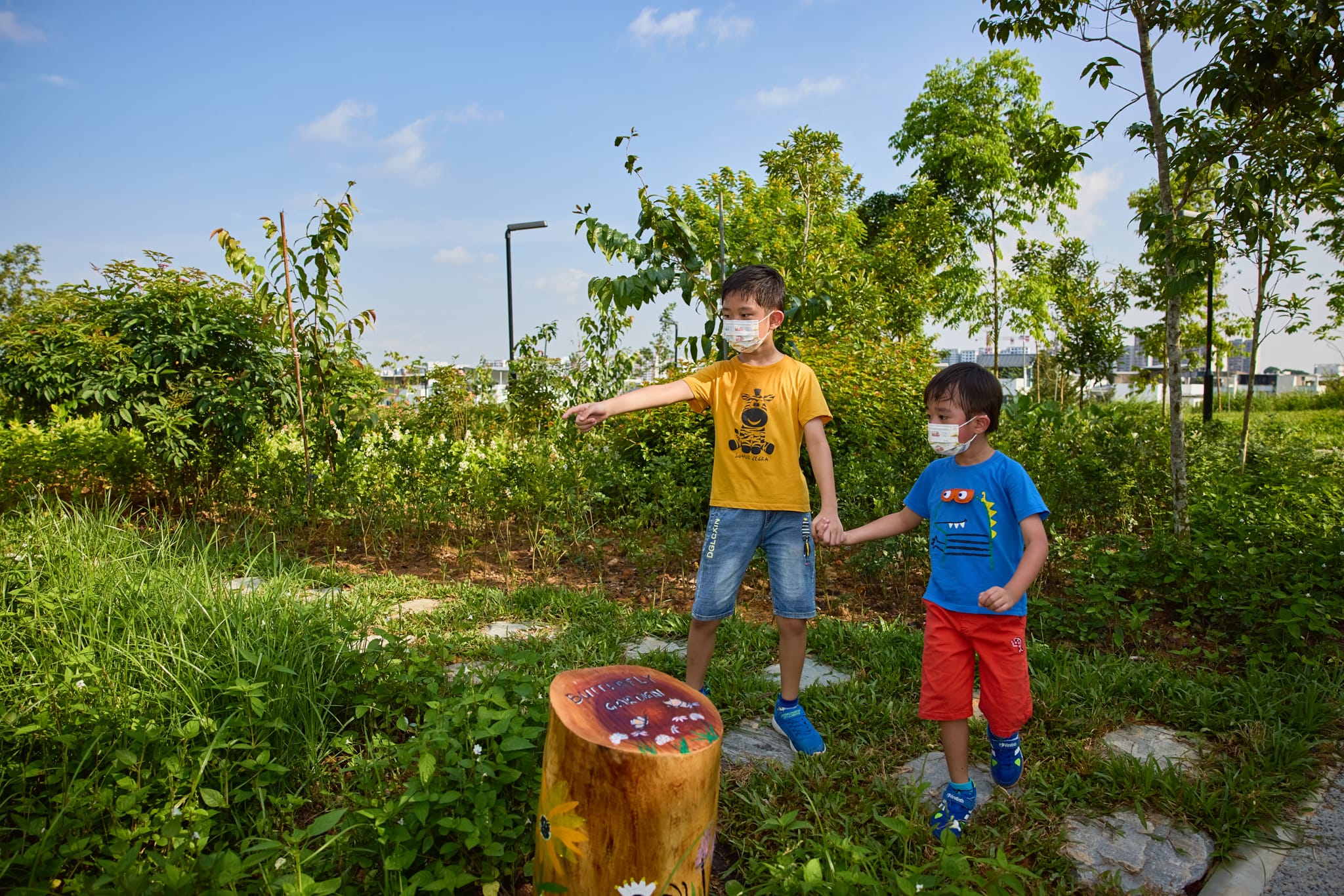 Two young boys pointing at the butterfly garden